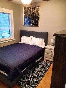 Un dormitorio con una cama azul y una ventana en Toronto Furnished Living- Niagara Falls, en Niagara Falls