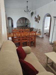 sala de estar con sofá y comedor en Encantadora casa rural con gran porche en San Roque
