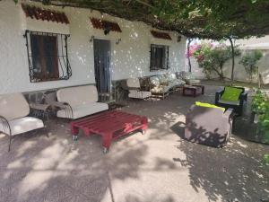 een patio met een tafel en stoelen en een huis bij Encantadora casa rural con gran porche in San Roque