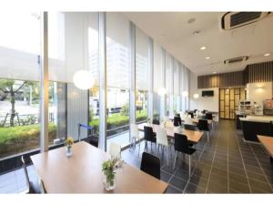 a restaurant with wooden tables and chairs and windows at R&B Hotel Tokyo Toyocho - Vacation STAY 40490v in Tokyo