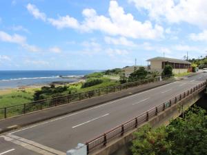 eine leere Straße mit dem Ozean im Hintergrund in der Unterkunft Yugaku Resort Kimukura - Vacation STAY 89356v in Tokunoshima