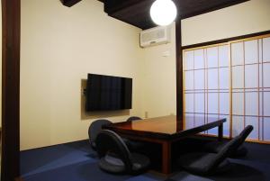 金沢市にあるKanazawa Hitomuneyado Kaisen - Vacation STAY 94237vのテーブル、椅子、テレビが備わる客室です。