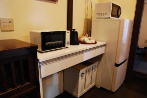 a kitchen with a counter with a microwave and a refrigerator at Kanazawa Hitomuneyado Kaisen - Vacation STAY 94237v in Kanazawa