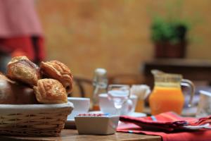 a table with a basket of bread and orange juice at La Maison des Consuls in Mirepoix