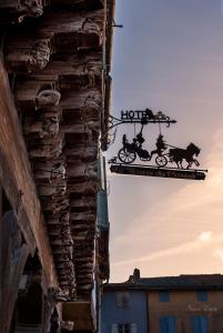 a sign hanging from the side of a building at La Maison des Consuls in Mirepoix +5 photos