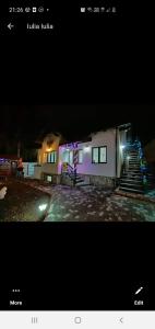 una foto de una casa por la noche con luces en Casa Andy, en Buşteni