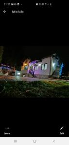 una foto de una casa por la noche con luces en Casa Andy, en Buşteni