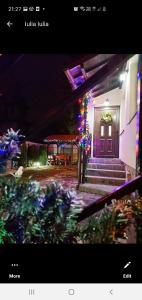a picture of a house with christmas lights at Casa Andy in Buşteni