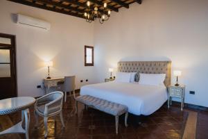 a bedroom with a white bed and a table and chairs at Iraola Hotel Boutique in Cafayate