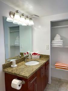 een badkamer met een wastafel en een grote spiegel bij Apartment Vacation Sunny Isles Beach in Sunny Isles Beach
