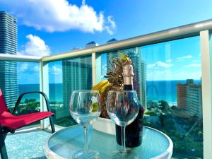 陽光島灘的住宿－Apartment Vacation Sunny Isles Beach，一张桌子,上面放着一瓶葡萄酒和两杯酒