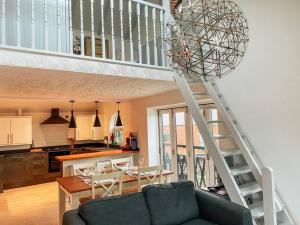 a living room with a staircase and a kitchen at Riverside loft apartment in Newport