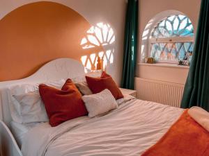 a white bed with red and white pillows on it at Riverside loft apartment in Newport