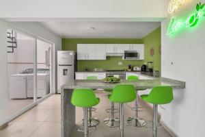 eine Küche mit grünen Stühlen und einer Arbeitsplatte in der Unterkunft +MS +Casa Limón +16 Pax +Wifi 150Mb in Querétaro