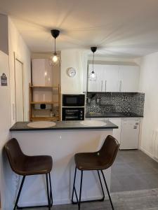 een keuken met 2 stoelen en een aanrecht in een kamer bij Épinal : superbe appartement en plein centre ville in Épinal