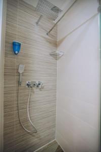 a shower with a hose in a bathroom at White Blue Ohrid in Ohrid