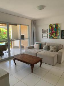 a living room with a couch and a coffee table at Condomínio Lírios Paraíso de Paz e Beleza in Mata de Sao Joao