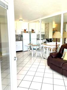 a living room and kitchen with a couch and a table at Ocean Overlook - Sea View at Symphony Beach Club! in Ormond Beach