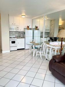 a kitchen with white appliances and a table and chairs at Ocean Overlook - Sea View at Symphony Beach Club! in Ormond Beach