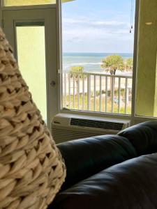a living room with a couch and a view of the ocean at Ocean Overlook - Sea View at Symphony Beach Club! in Ormond Beach