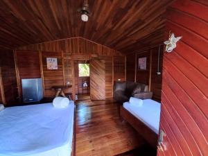 um quarto com duas camas e um sofá num quarto em Cabañas Los Laguitos Rio Celeste em El Achiote