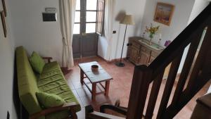 a living room with a green couch and a table at Villa Cubas in Güimar