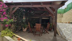 eine hölzerne Pergola mit Stühlen und einem Tisch auf der Terrasse in der Unterkunft Villa Cubas in Güímar