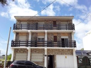 a building with a balcony on the side of it at Departamento 6 personas con vista al mar in Mar de Ajó