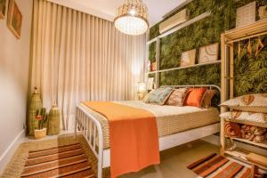 a bedroom with a bed with an orange blanket at Lindo apartamento no mar de Itaparica in Vila Velha