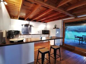 een keuken met een aanrecht en krukken in een kamer bij Cottage les Pyrénées au bord de l'eau in Barbazan