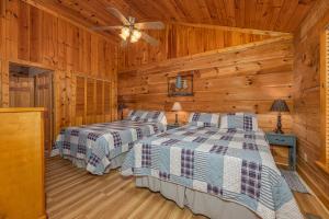 1 dormitorio con 2 camas en una cabaña en Firefly Hollow Cabin - Smoky Mountains - Soaky Mountain Water Park - Sevierville Convention Center, en Pigeon Forge