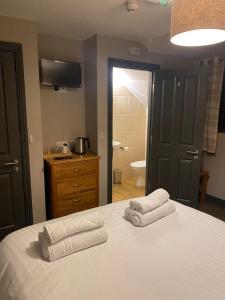 ein Schlafzimmer mit einem Bett mit zwei Handtüchern darauf in der Unterkunft Duke Of York in Hazel Grove
