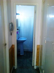 a bathroom with a sink and a blue toilet at Departamento 2 ambientes PB a metros del mar in Mar de Ajó