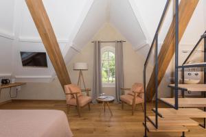 Schlafzimmer im Dachgeschoss mit 2 Stühlen und einem Bett in der Unterkunft La Maison du Môle in Aigues-Mortes