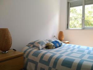 サン・アドリア・デ・ベソスにある2 BEDROOMS and 2 BATHROOMS FOR 5 PAX, SWIMMING POOL, FREE PARKING and NEAR THE BEACH!のベッドルーム1室(青と白のベッド、ランプ2つ付)