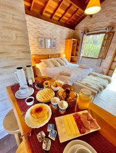 una habitación con una mesa con alimentos para el desayuno en Flor de Minas, en Monte Verde