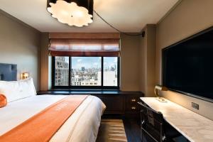 a hotel room with a large bed and a large window at Soho Grand Hotel in New York