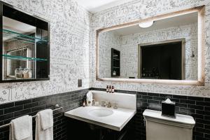a bathroom with a sink and a mirror and a toilet at Soho Grand Hotel in New York