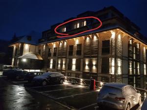 科帕奧尼克的住宿－Family apartmans Hari - Apart Hotel & spa Zoned, Kopaonik - Children up to 13 years free!，建筑的侧面有 ⁇ 虹灯标志