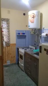 una cucina con lavandino e piano cottura forno superiore di Departamento 1 ambiente 3 personas PB a metros del mar a Mar de Ajó