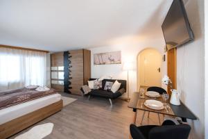 Agrimonia - möbilierte Ferienwohnung mit Balkon في دافوس: غرفة نوم مع سرير وغرفة معيشة