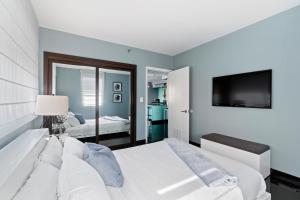 1 dormitorio con 1 cama blanca y TV en Casa Grande Suites on Ocean Drive, en Miami Beach