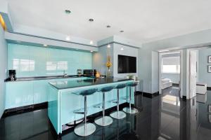 una cocina azul con barra con taburetes en Casa Grande Suites on Ocean Drive, en Miami Beach