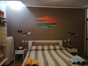 1 dormitorio con 1 cama y una pintura en la pared en B&B Annalu', en Guspini