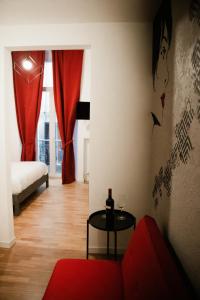 un soggiorno con divano rosso e tavolo di BED and BREAKFAST il Duomo ad Ascoli Piceno