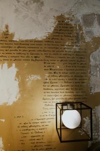 a lamp in front of a wall with writing at BED and BREAKFAST il Duomo in Ascoli Piceno