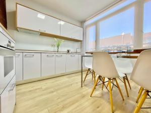 a kitchen with white cabinets and a table and chairs at Charming La Casa de La Castellana in Madrid