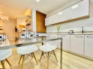 a kitchen with a long counter with white cabinets at Charming La Casa de La Castellana in Madrid
