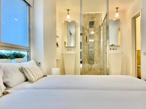 a bedroom with a large white bed and a shower at Charming La Casa de La Castellana in Madrid