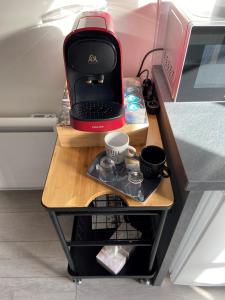 a small table with a keyboard and cups on it at ENGHIEN-LES-BAINS : studio au coeur du centre ville in Enghien-les-Bains